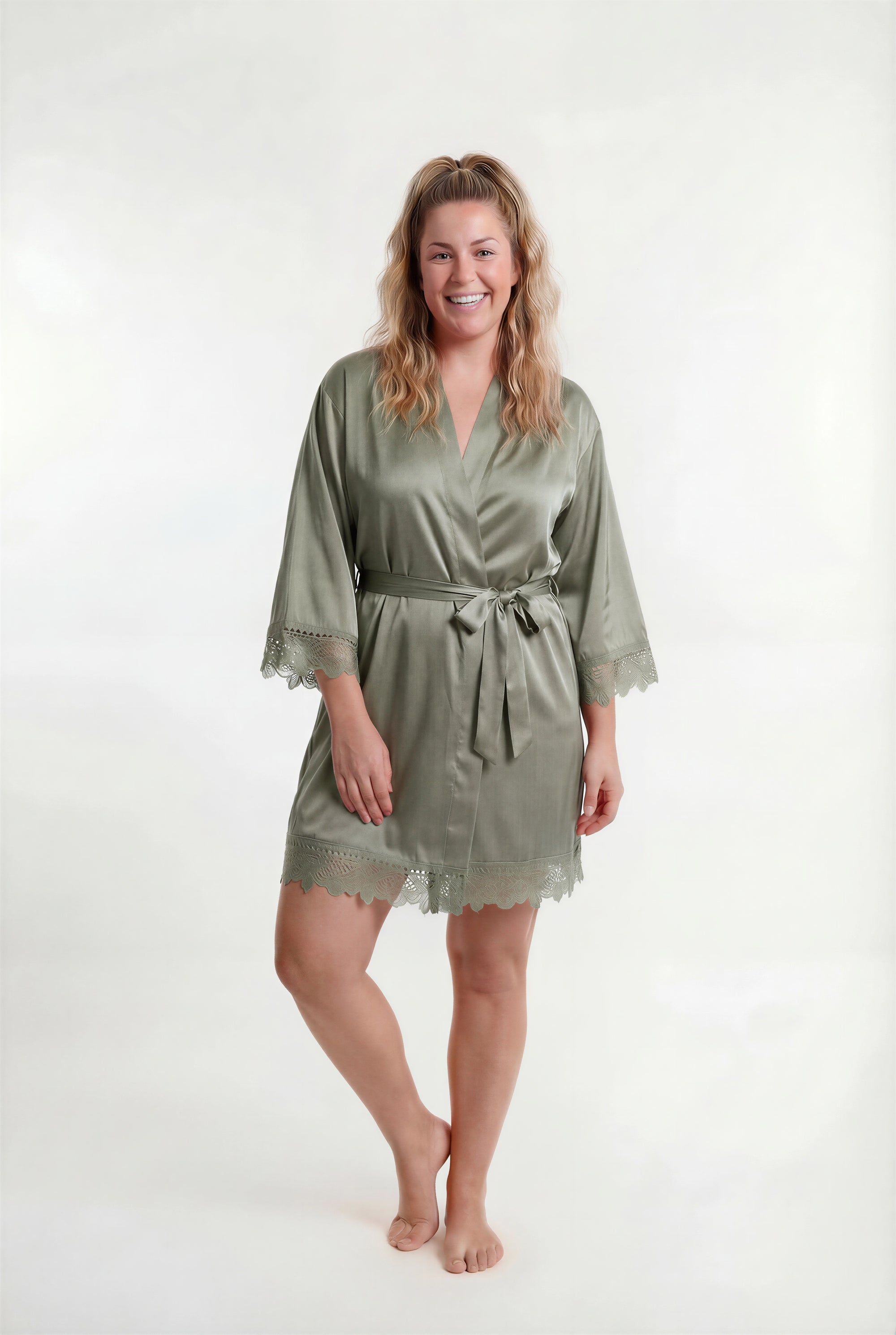 Woman wearing a green satin robe on a white background